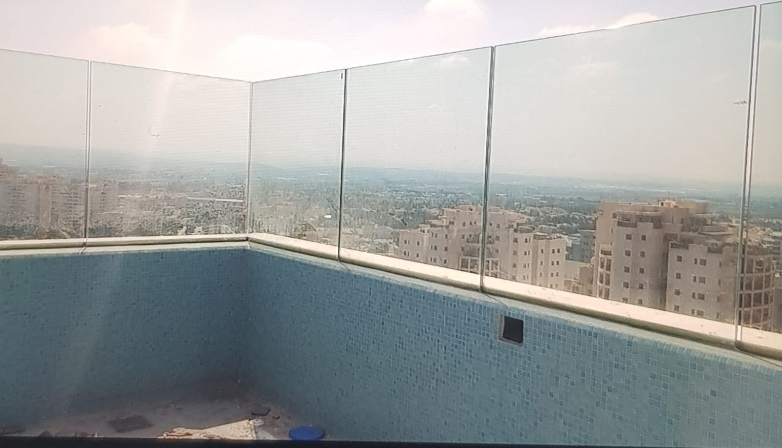 מעקה זכוכית שתולה בתעלת ברזל בהתקנה רטובה